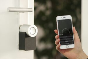 smartphone Apple iPhone doré tenu à la porte