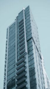 Un immeuble de grande hauteur élégant doté d'une façade en verre moderne sur fond de ciel bleu clair.
