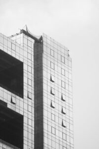Un gratte-ciel moderne et élégant avec une façade en verre réfléchissant domine le paysage urbain.