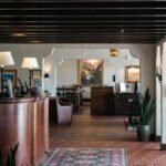 A woman is standing at the front desk of a restaurant