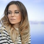 woman wearing black and white striped top and round eyeglasses
