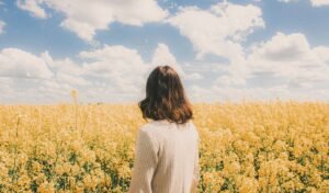 Woman standing in a field of yellow flowers