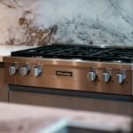 Modern stainless steel gas range with marble backsplash